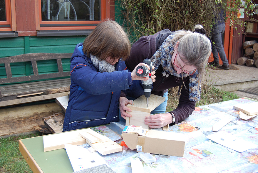 Eine Frau und ein Kind bauen einen Nistkasten, Foto: NABU RLP